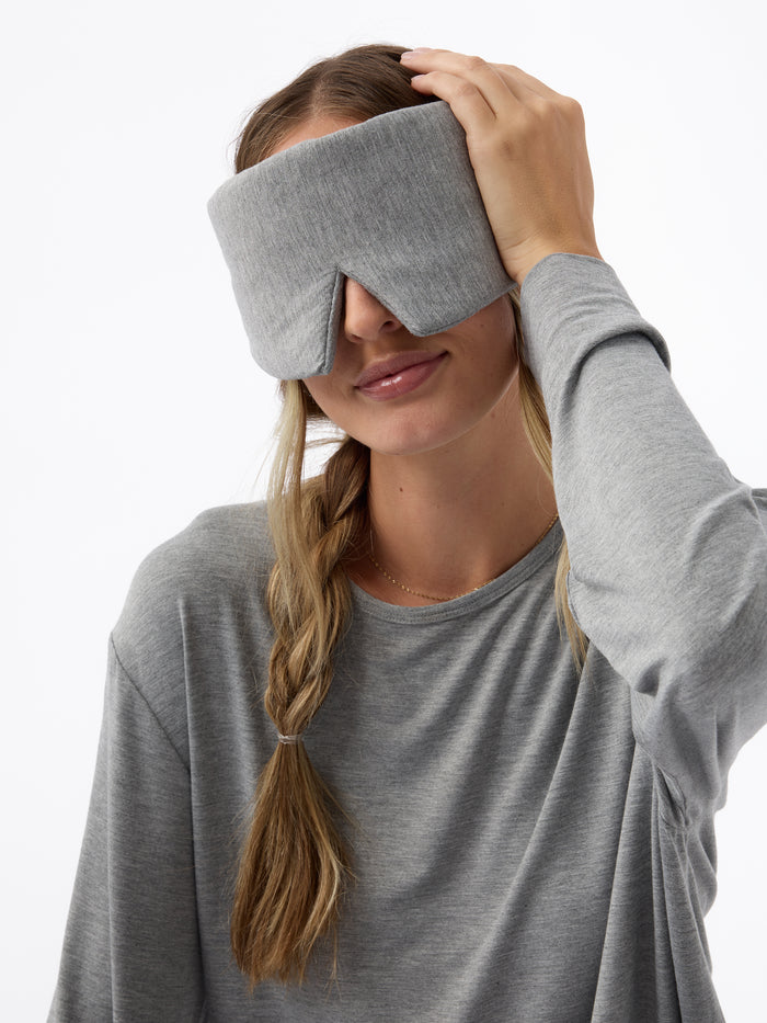 A woman wears the Cozy Earth Adjustable Bamboo Sleep Mask in Grey. |Color:Grey