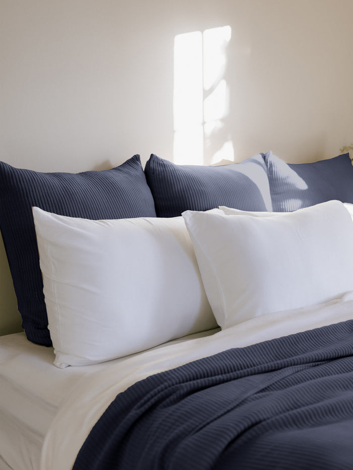 Navy euro coverlet shams behind white pillows on bed |Color:Navy