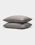 Two neatly stacked Bamboo Coverlet Shams by Cozy Earth in gray with stripes, displayed on a plain white background.|Color:Charcoal