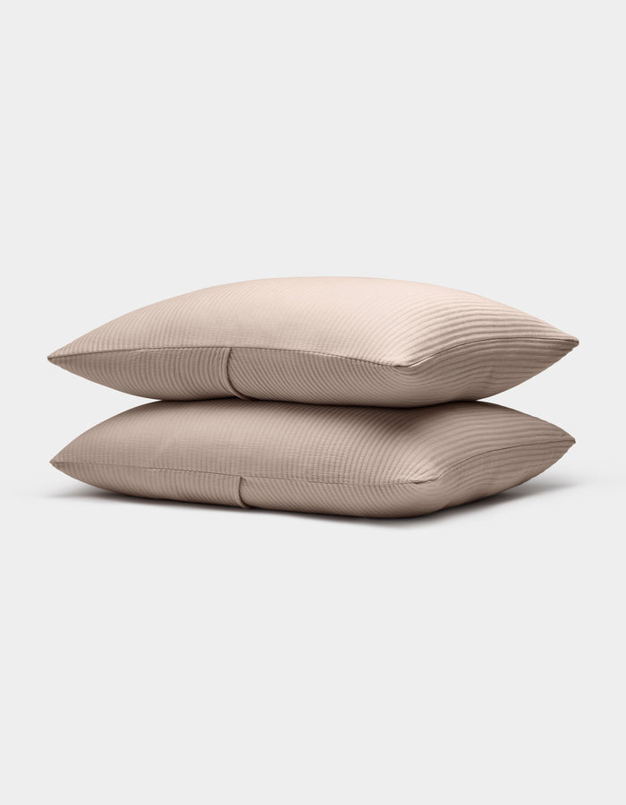 Two Bamboo Coverlet Shams by Cozy Earth, in light beige with a subtle ribbed texture, are stacked neatly against a plain white background.|Color:Driftwood