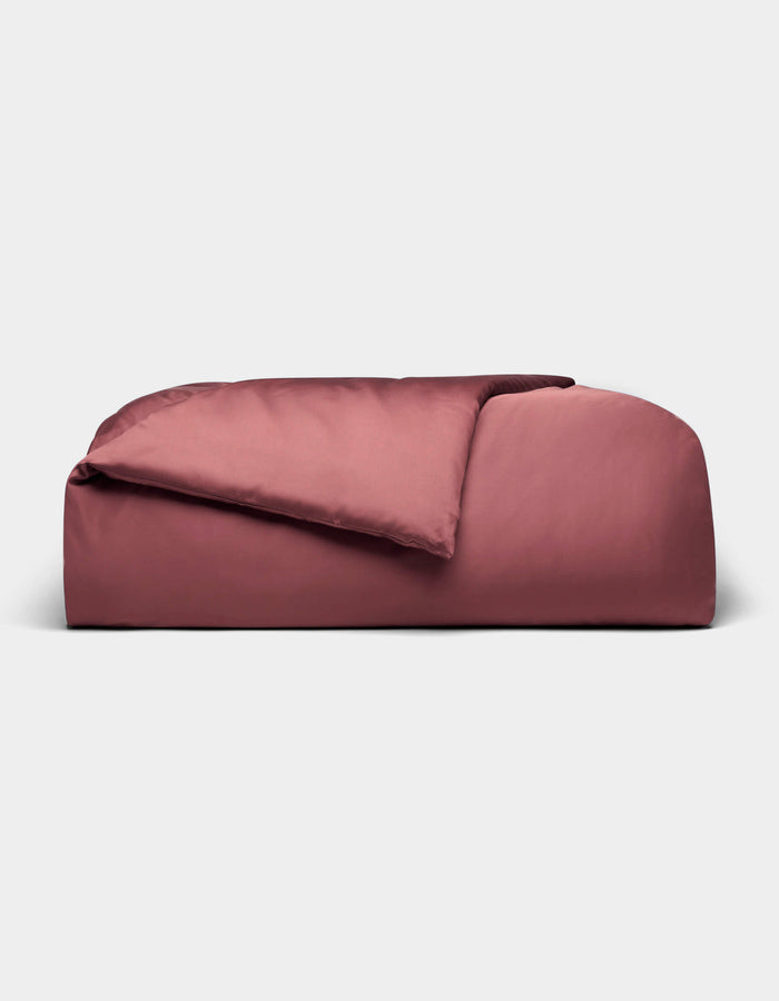 A rectangular, rose-colored Bamboo Duvet Cover from Cozy Earth with a soft, smooth texture and a gentle top fold, displayed against a plain light gray background.|Color:Mulberry