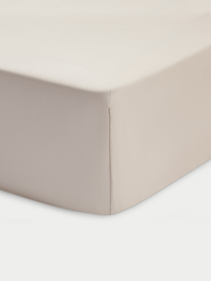A close-up of the Cozy Earth Bamboo Fitted Sheet in beige, showing smooth fabric and a stitched seam running vertically down the tightly covered mattress corner.|Color:Driftwood