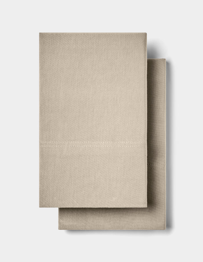Two neatly folded Cozy Earth Bamboo Jersey Pillowcases are stacked together against a plain white background.|Color:Driftwood