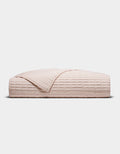 The Cozy Earth Bamboo Jersey Quilt, shown folded in blush-pink with a quilted grid pattern, is displayed against a plain white background.|Color:Petal