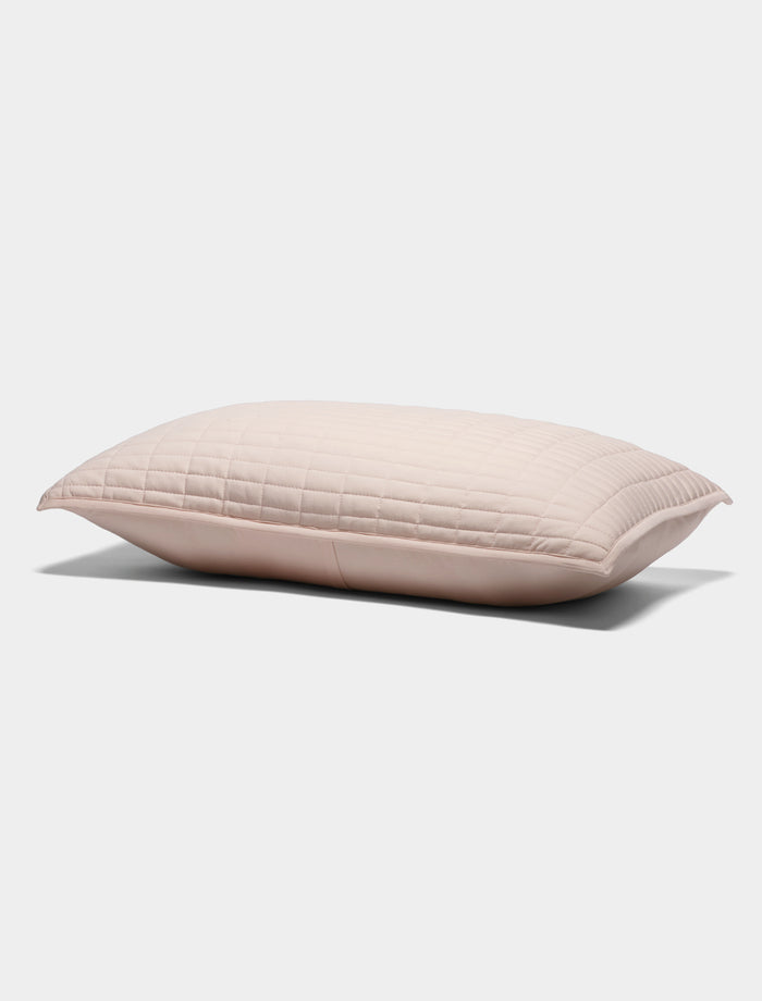 The Cozy Earth Bamboo Jersey Quilted Shams features a light pink rectangular design with a quilted pattern, displayed on a plain white background.|Color:Petal