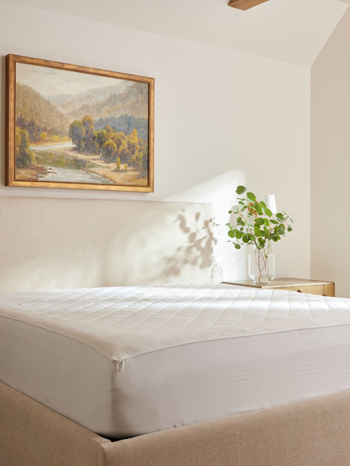 Bamboo Mattress Pad on bed with nightstand and painting in the room