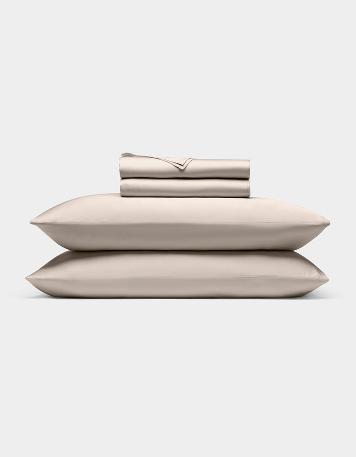 A neatly stacked Cozy Earth Bamboo Sheet Set, featuring two pillows, a folded fitted sheet, flat sheet, and pillowcases, displayed against a plain white background.|Color:Driftwood