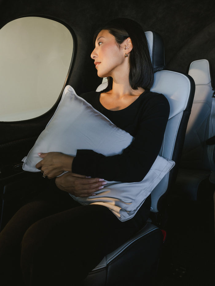Woman in car holding travel pillow with light grey case in her lap |Color:Light Grey