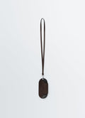 Bell glasses holder in dark brown leather with strap by LEMAIRE front on white background