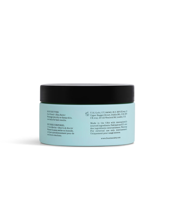 A light blue Cozy Earth Body Butter jar with a black lid is shown from the back, displaying an English and French label with product description, ingredients, directions, and company details.|Size:Full Size