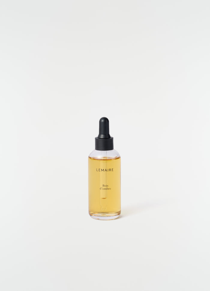 Bois D'Ombre perfume dropper bottle with amber liquid and black cap LEMAIRE on white background