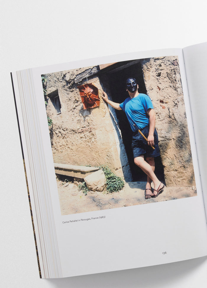 Carlos Peñafiel Book showing man in blue shirt and black mask against rustic wall worn by model LEMAIRE