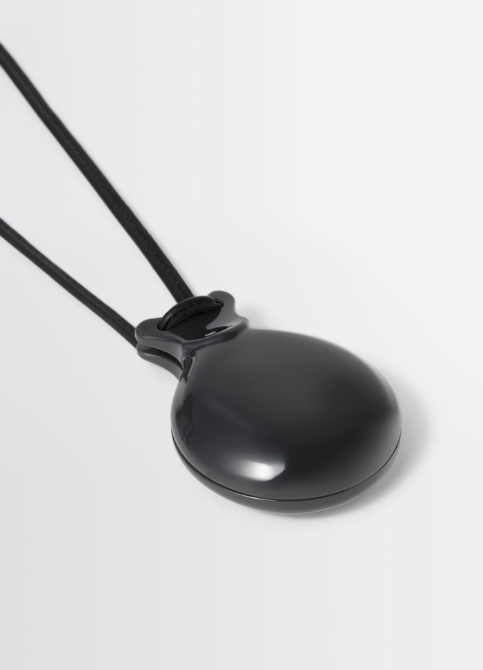Castanet mirror black lacquered with leather strap by LEMAIRE close-up detail on white background