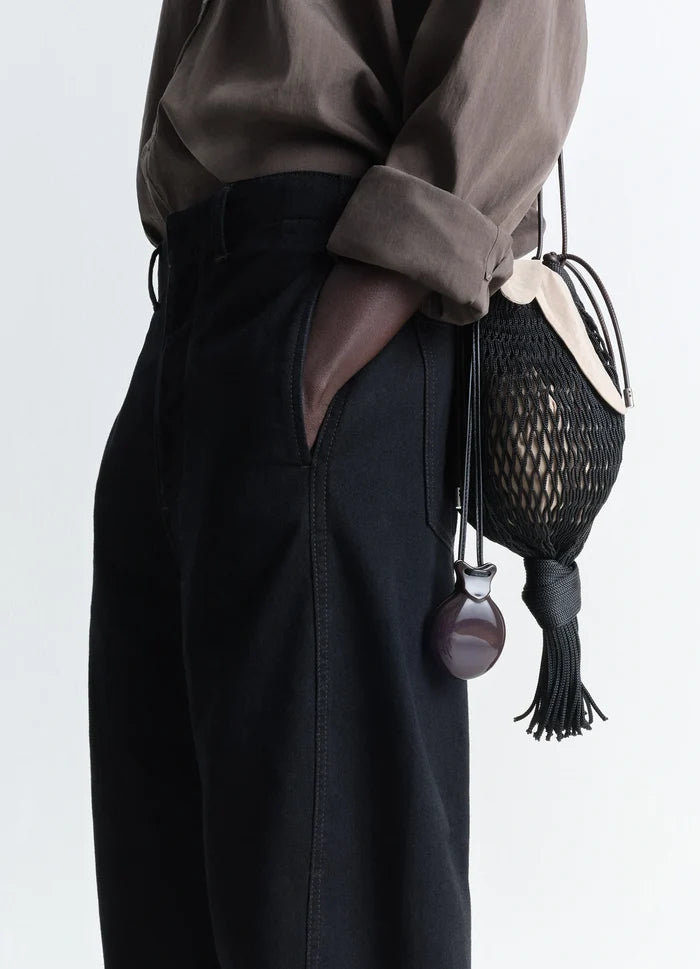 Lemaire Castanet Necklace in Dark Brown Resin, model shot, side perspective view elegant curved pendant