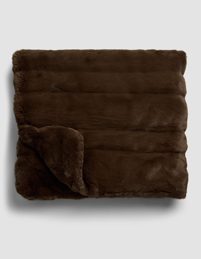 The Cozy Earth Channel Cuddle Blanket, shown folded with one corner turned over, features soft, plush dark brown faux fur and is displayed on a light gray background.|Color:Cedar
