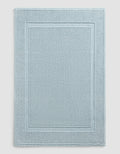 The Cozy Earth Classic Bath Mat features a rectangular shape in light blue with a textured surface and double border design, where two rectangles elegantly frame the center for a simple, refined look.|Color:Harbor Mist