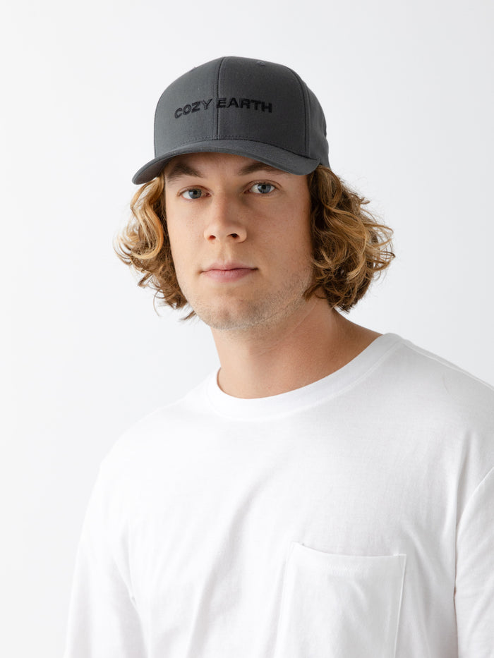 A man wearing a grey cap with 'COZY EARTH' text on a white background |Color:Charcoal/Black