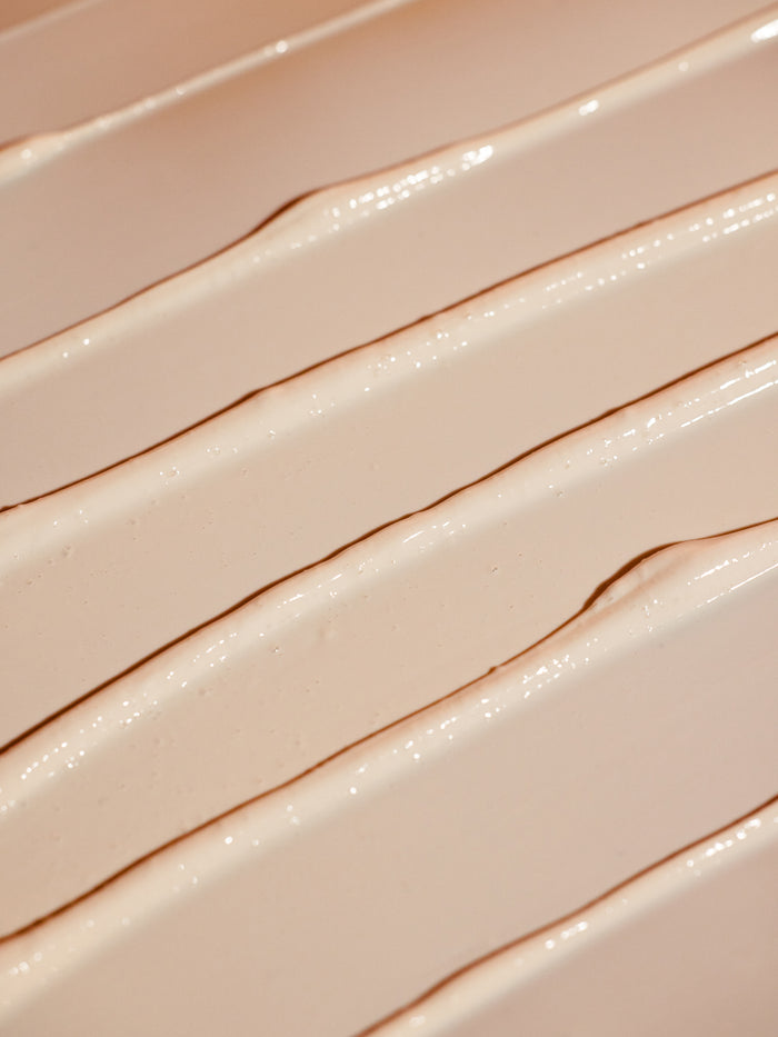 A close-up of the creamy, smooth lines of Cozy Earth's Clay Mask showcases a textured beige pattern on the surface. The light highlights intricate ridges and valleys, adding depth and richness to its appearance. |Size:Full Size