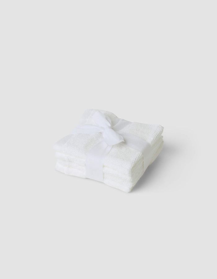 A stack of three folded Cozy Earth Complete Cleansing Cloths, tied with a white ribbon and set against a plain light gray background.|Color:White