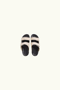Pair of white canvas and black rubber sandals on a white background