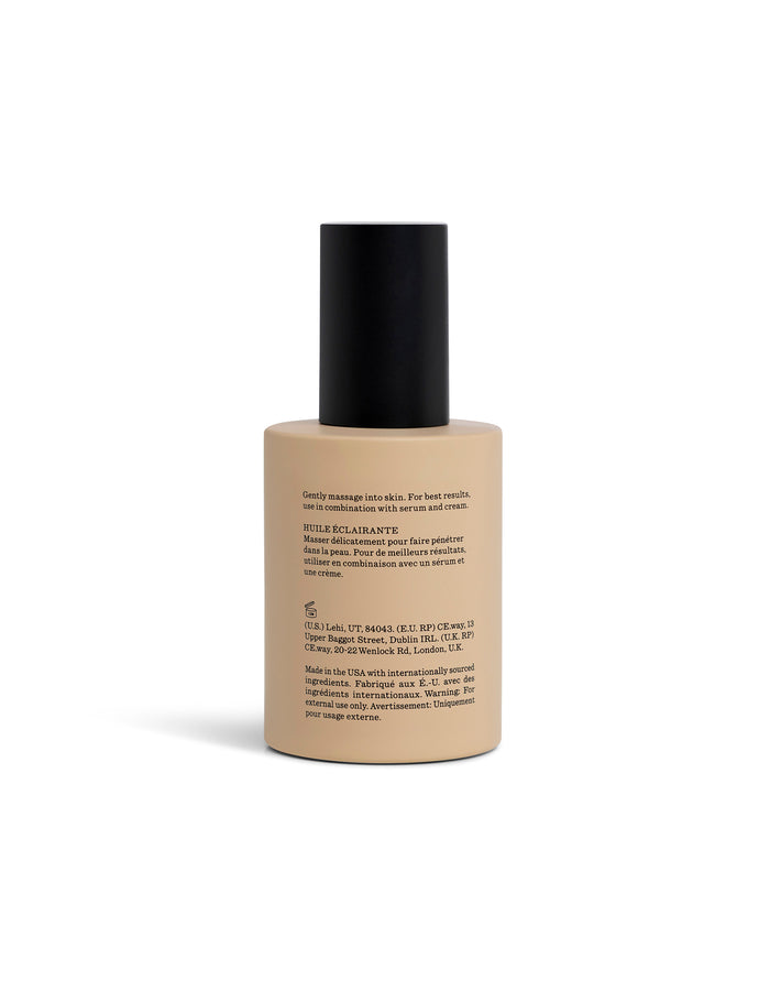 A beige bottle of Brightening Vitamin C oil turned towards the back with a black cap sits on a white background