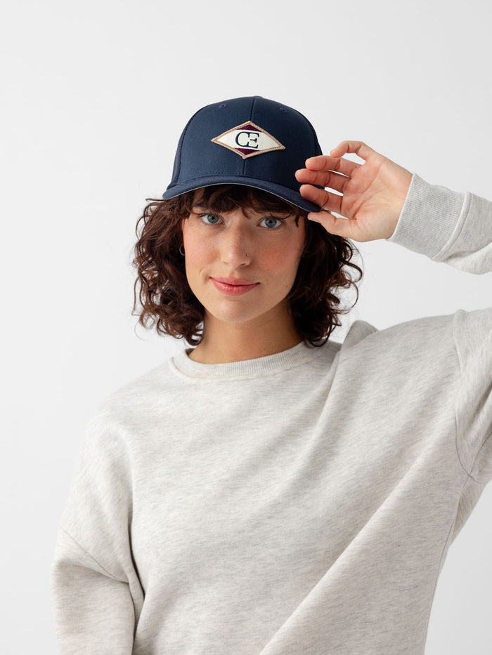 Woman wearing navy diamond mesh trucker hat looking at the camera |Color:Navy
