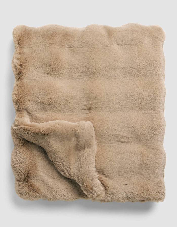 The Cozy Earth Double Bubble Cuddle Blanket is neatly folded, featuring soft, beige faux fur with one corner turned up to display its plush, fluffy underside.|Color:Brandy