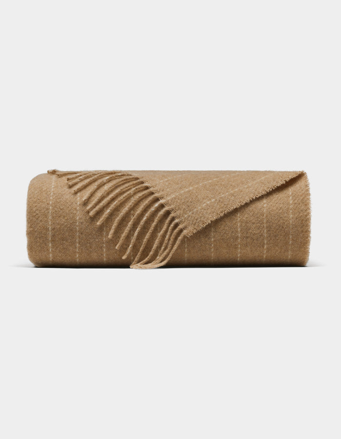 The Florence Throw by Cozy Earth is a light brown wool blanket with subtle white stripes and fringed edges, shown against a plain white background.|Color:Brandy