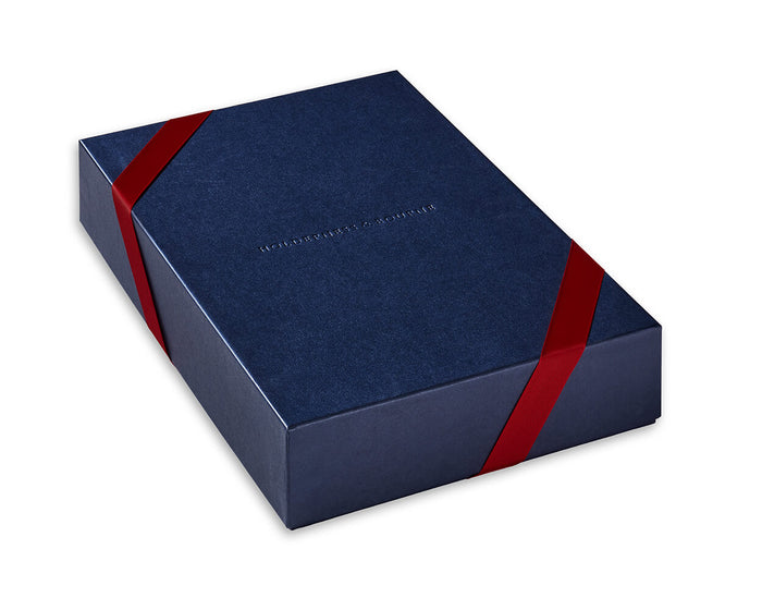 Navy Gift Box by Holdenness & Bourne, with red diagonal ribbons, fits three shirts or two layering pieces; debossed brand name centered on lid.