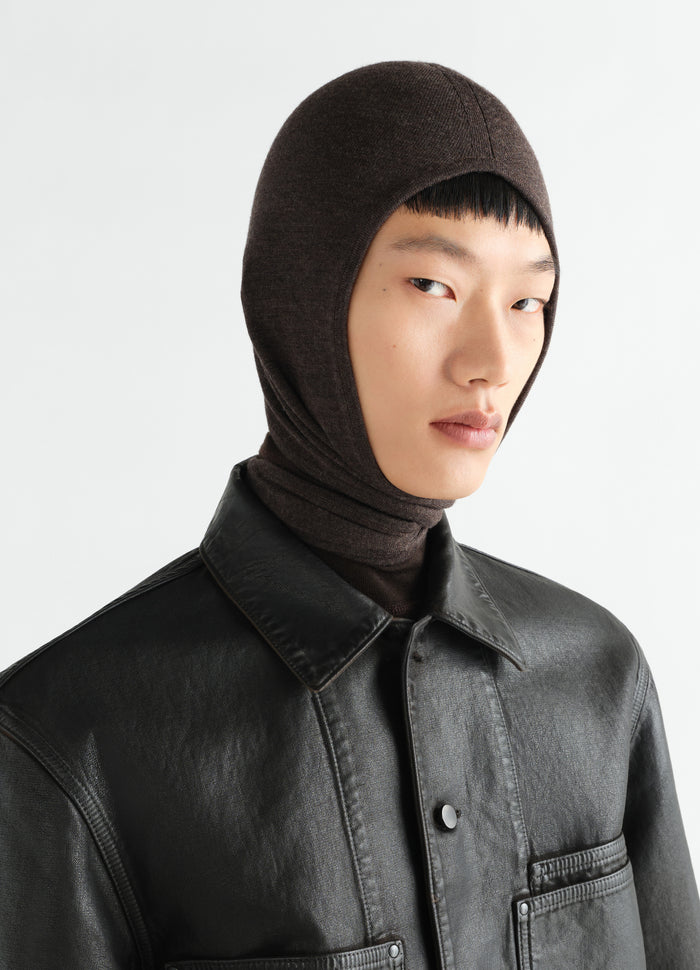 Head scarf in fine brown wool by LEMAIRE worn by a model with black leather jacket close-up side view