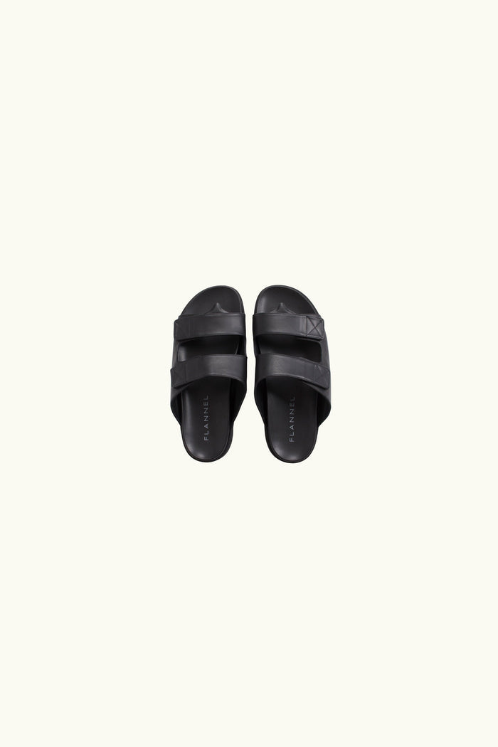 Pair of black slides leather on a white background