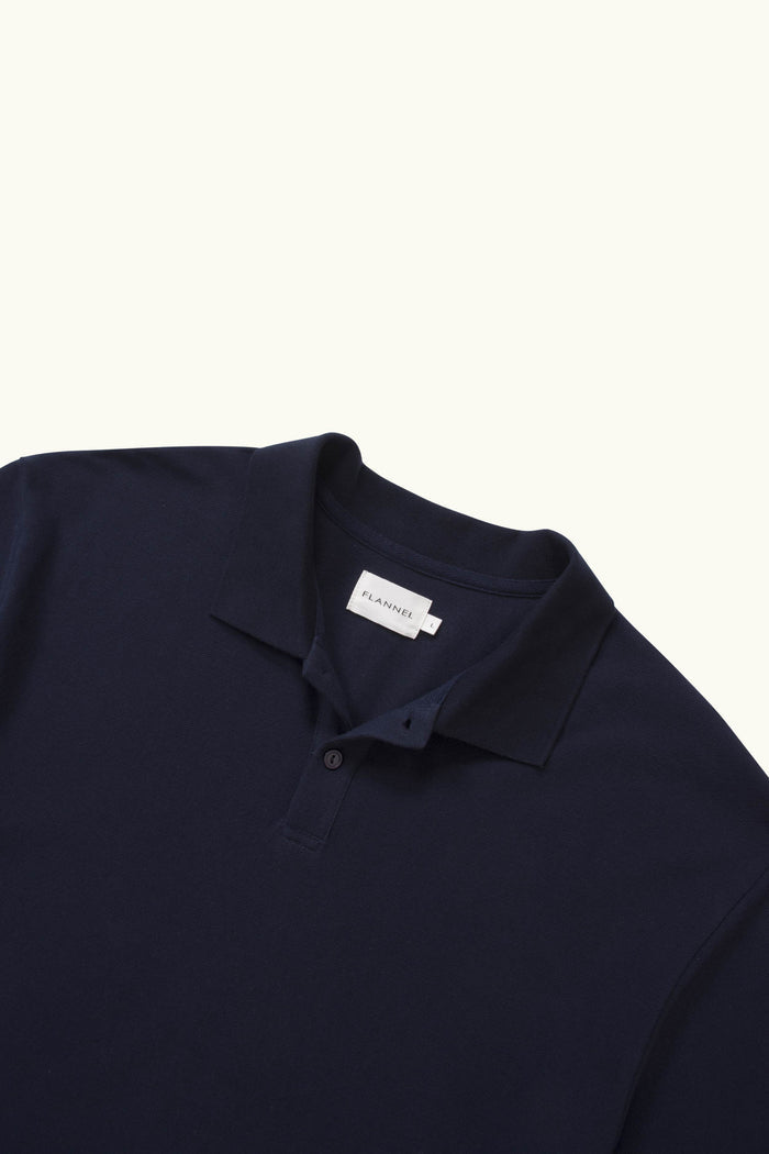 Close up of navy polo on white background