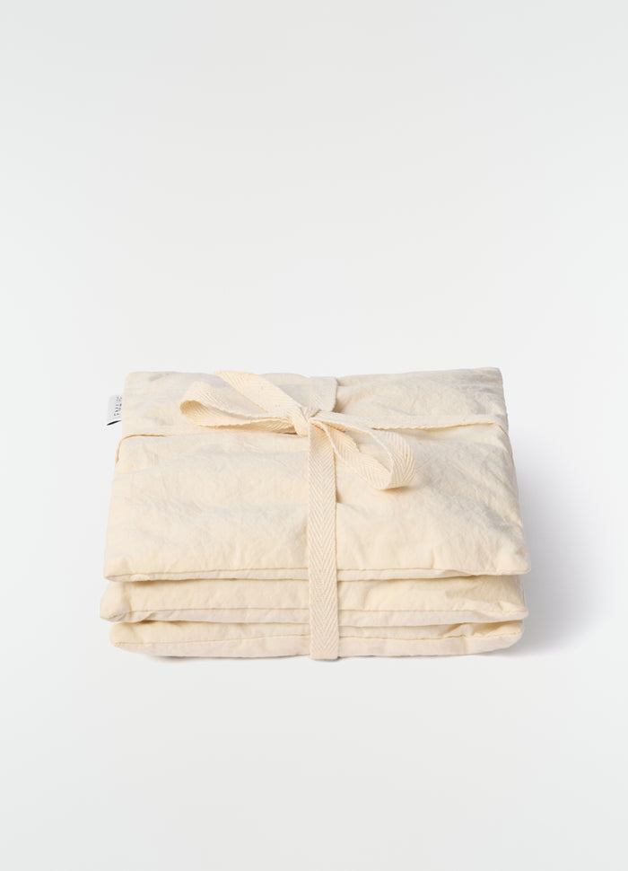 Lavender cushion S in beige cotton with tied detail by LEMAIRE on plain white background