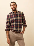 Man wearing a red plaid shirt against a beige background