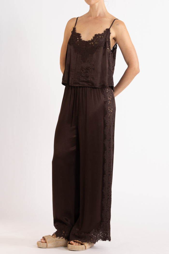 Woman wearing matching brown camisole and pant on a white background