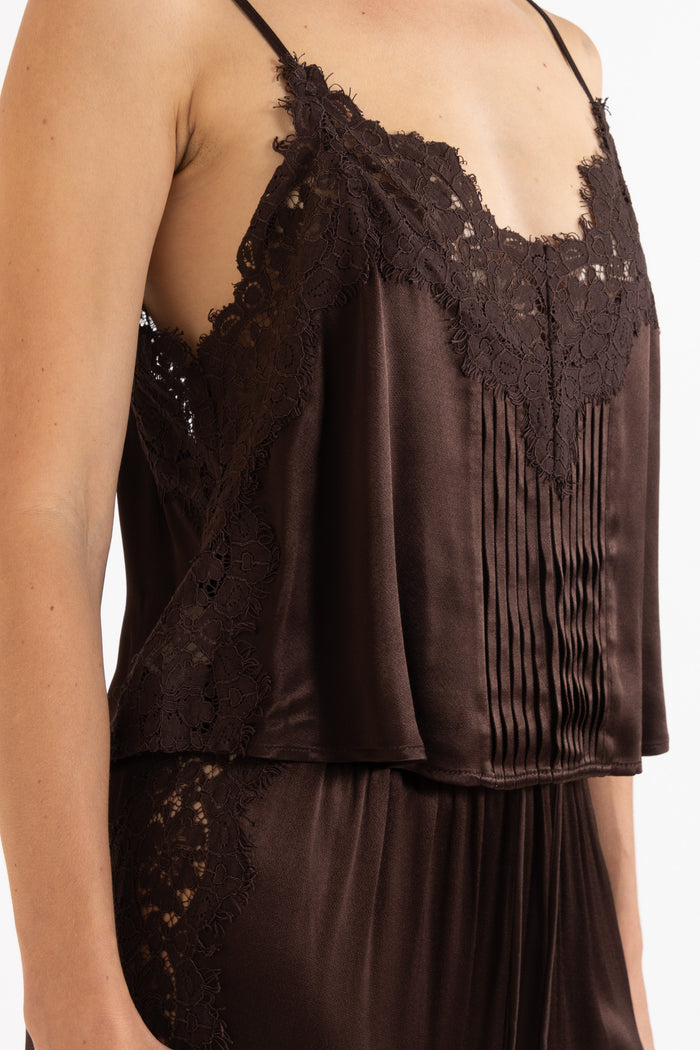 Woman wearing matching brown camisole and pant on a white background