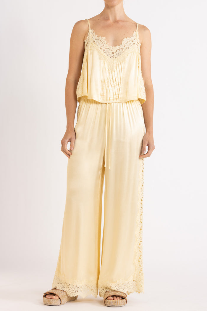 Woman wearing matching vanilla lace-trimmed camisole and pant.