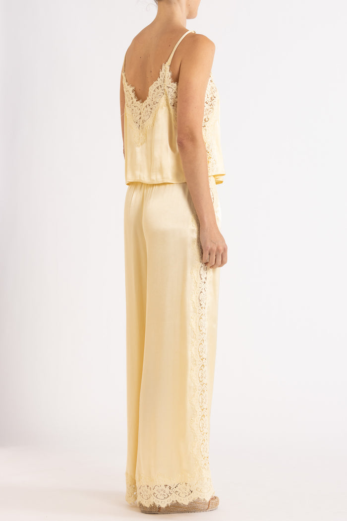Woman wearing matching vanilla lace-trimmed camisole and pant.