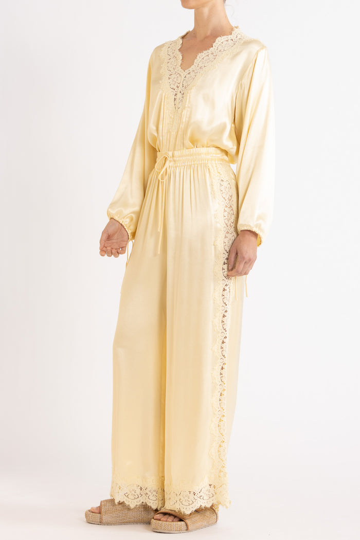 Woman wearing matching Vanilla lace-lined long sleeve top and pant on a white background