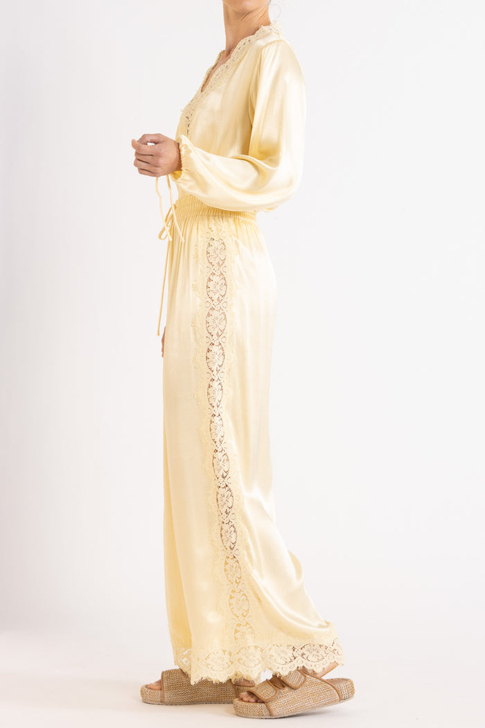 Woman wearing matching Vanilla lace-lined long sleeve top and pant on a white background