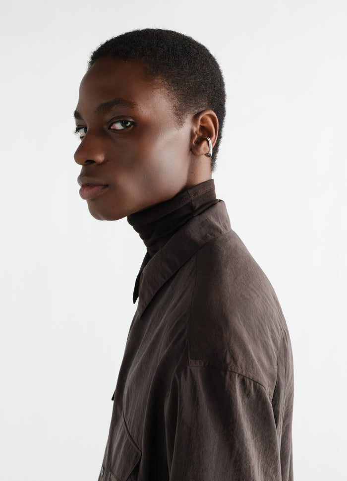 Long Drop Earcuff in silver worn by model LEMAIRE side profile with brown shirt and turtleneck
