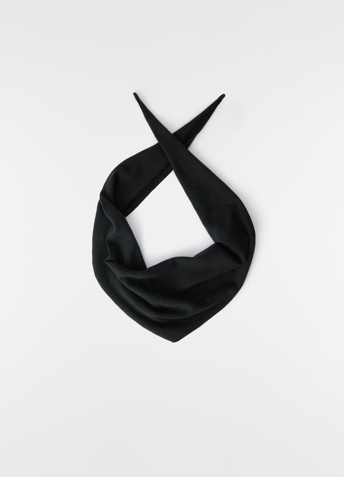 Triangular black merino wool scarf by LEMAIRE laid flat with pointed ends crossed on white background
