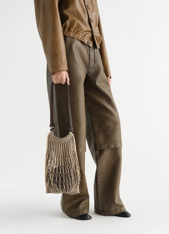 Medium beige cotton net shopping bag LEMAIRE worn by model holding bag side view