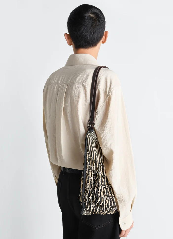 Lemaire Filt Net Shopping Bag in Nylon mesh with leather, model shot, back view draped on shoulder