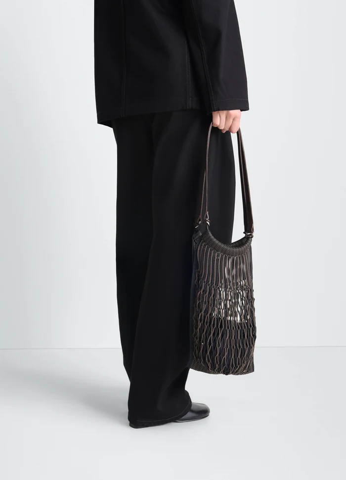 MEDIUM FILT NET SHOPPING BAG in nylon mesh and vegetable-tanned lea, model shot, side view handheld by model