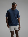A man wearing the Cozy Earth Men’s All Day Tee in Eclipse stands against a plain gray background, looking to his left with a neutral expression.|Color:Eclipse