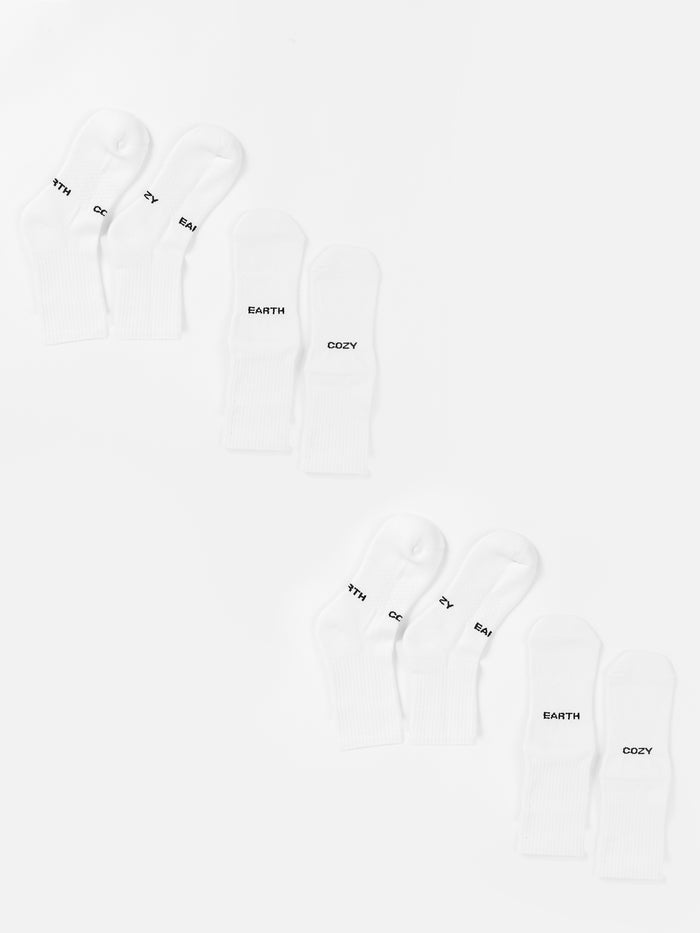 Two sets of three pairs of white Essential Calf Sock 4-Packs from Cozy Earth are arranged in two rows on a white background. Each sock is labeled with the words "MYTH," "EARTH," or "COZY" in black text near the toes. The arrangement is neat, with one set of socks mirroring the other. |Color:White