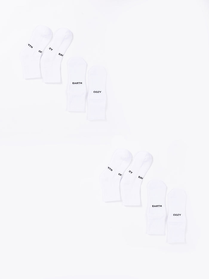 The Essential Quarter Sock 4-Pack from Cozy Earth includes eight white socks arranged in two rows, with each row containing four pairs. The socks feature various words printed on them, such as "EARTH," "COZY," and "THY." The plain white background provides a clean and minimalist appearance. |Color:White