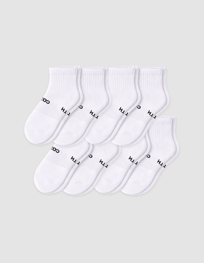 The Cozy Earth Men's Essential Quarter Sock 8-Pack features eight pairs of white socks with ribbed cuffs, neatly arranged in overlapping rows. Some have black text near the toe area, all displayed on a plain light background.|Color:White