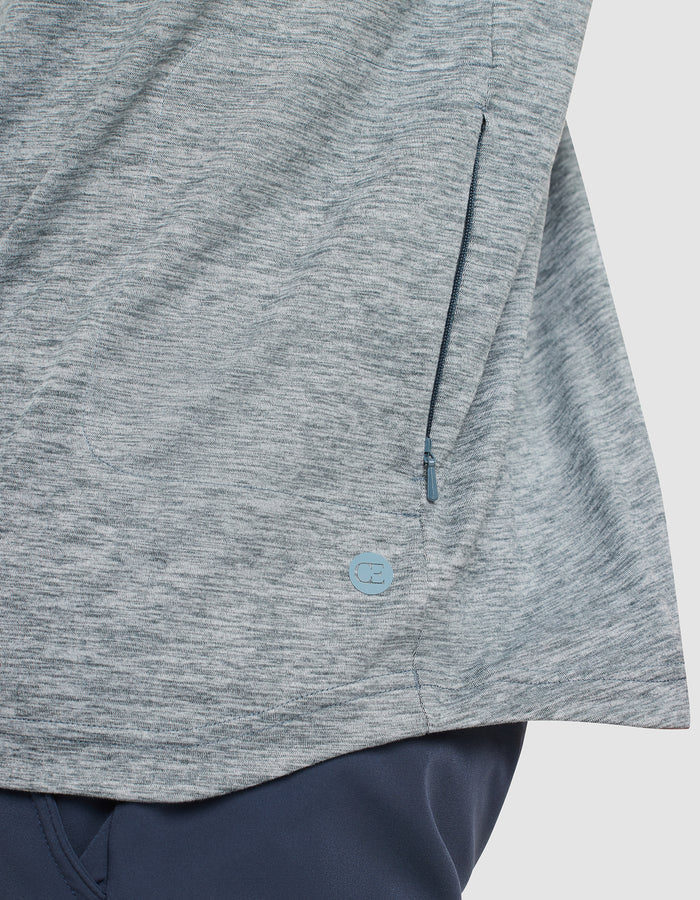 Close-up of a heather gray zippered pocket on the Cozy Earth Men's Lightweight Performance Hoodie, featuring a small round blue logo near the seam, paired with dark blue pants. |Color:Heather Dawn